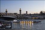 Alexandre III bridge and tour boat  on river Seine at sunset